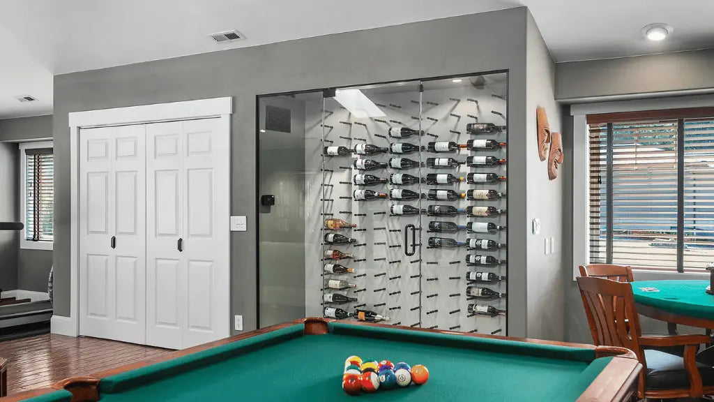 Contemporary home wine cellar with glass enclosure and wall-mounted bottle racks next to a pool table | Wine Guardian Dealer